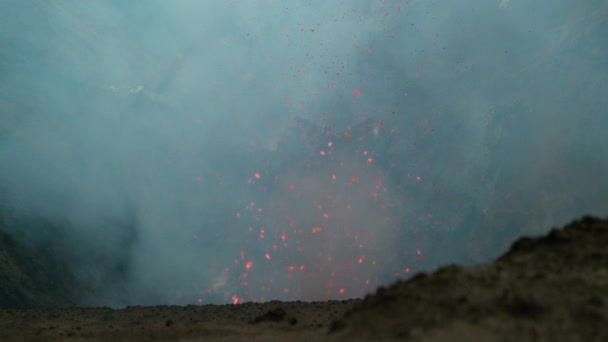 スローモーション:噴出する溶岩の破片が活火山から空中を飛ぶ. — ストック動画