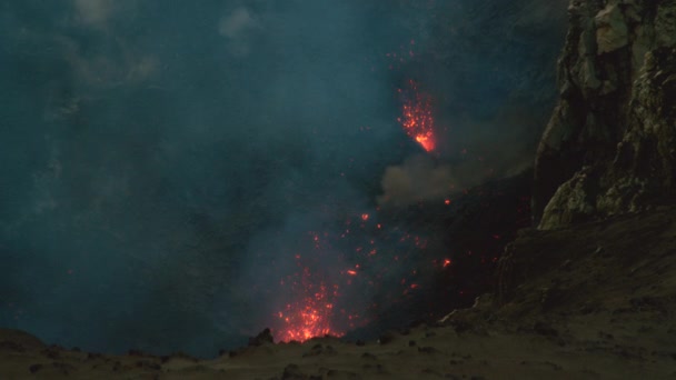 SUPER MOCIÓN LENTA: Brillantes pedazos rojos de magma vuelan en el aire después de la erupción . — Vídeo de stock