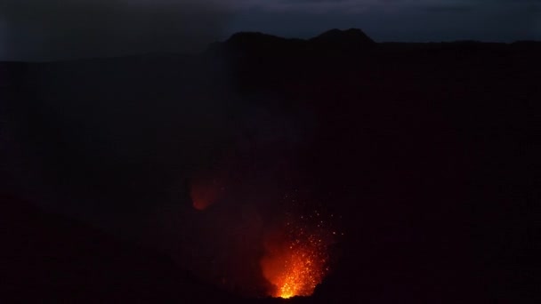Lave orange et cendres sont soufflées dans l'air lors d'une éruption volcanique rugissante .