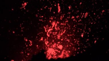 Yavaş Hareket: Aktif volkanik krater parlak turuncu magma parçaları püskürtüyor.