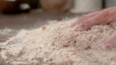 Tanımlanamayan erkek fırıncı ahşap tezgahta pizza hamuru yoğuruyor..