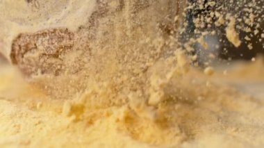 Slow Motion: Kırsal ekmek masaya düştüğünde havada uçuşan sarı un.