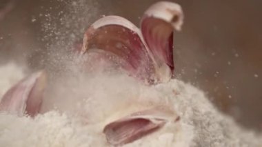 Slow Motion: Mor sarımsak karanfilleri ağarmış un yığınına atılır.
