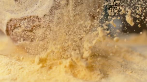 SLOW MOTION: Yellow flour flying in the air as rustic loaf falls onto the table. — Stock Video