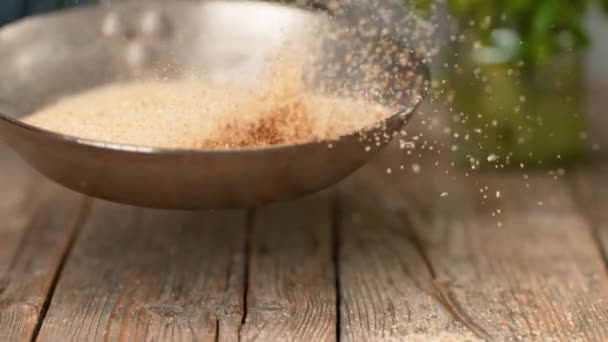 Zeitlupe, Makro: Haufen abgestandener Brotkrumen werden in einer Metallpfanne geröstet. — Stockvideo