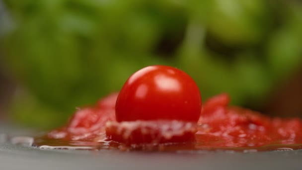 MACRO: Mogna runda tomater faller ner i en pöl med marinarasås på bordet. — Stockvideo