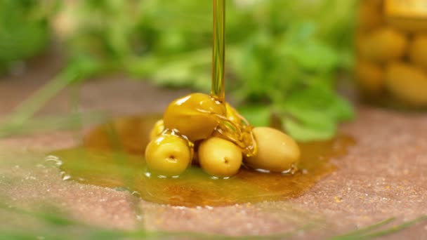 MACRO: El aceite de oliva virgen se vierte sobre las aceitunas curadas sentadas en el mostrador . — Vídeos de Stock