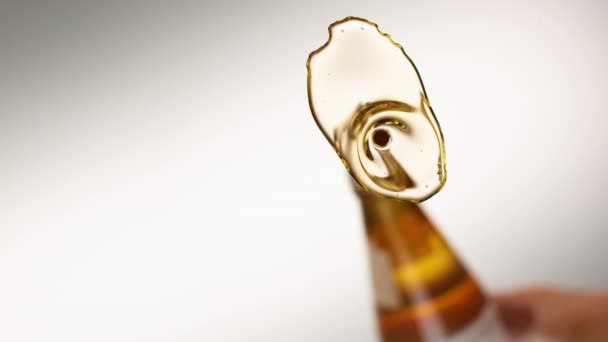 BOTTOM UP: Goldenes natives Olivenöl extra wird auf eine glasige Oberfläche gegossen. — Stockvideo