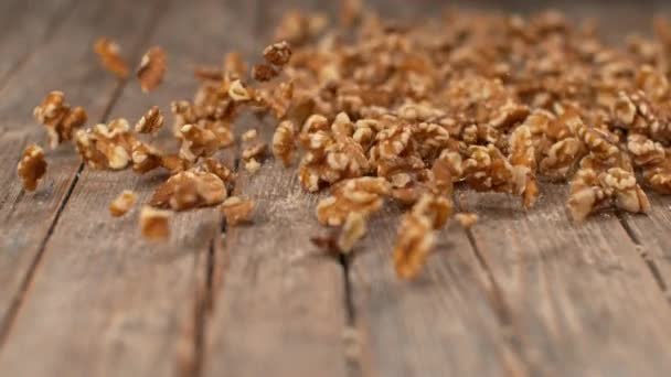 SLOW MOTION, DOF: Heerlijke biologische walnotenpitten rollen over de houten tafel. — Stockvideo