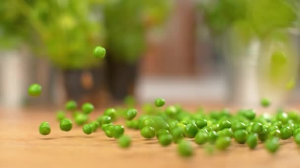 SLOW MOTION: Cinematic shot of homegrown green peas rolling down wooden counter. — Stock Video