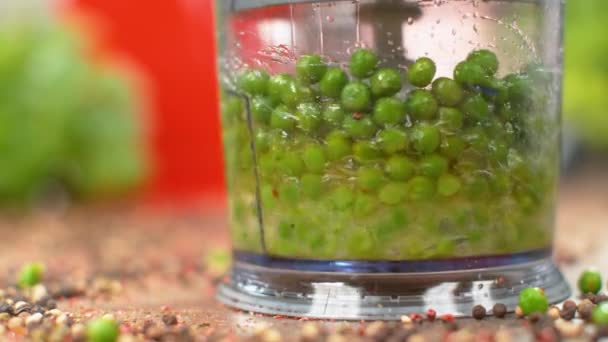 SLOW MOTION, MACRO: Raw organic green peas are blended in a food processor. — Stock Video