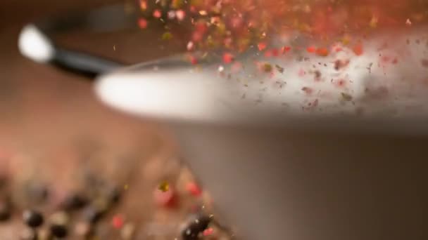 MOCIÓN LENTA: Las coloridas cáscaras de pimienta salen volando de una cacerola de metal vacía . — Vídeos de Stock