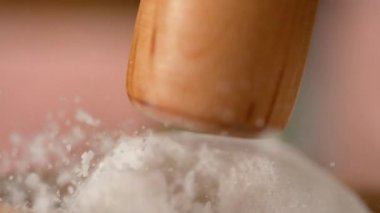 Beyaz deniz tuzu taneleri bir tokmakla vurulduğunda havada uçar..