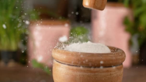 MACRO: Unrecognizable woman crushes a chunk of rock salt with a wooden pestle. — Stock Video