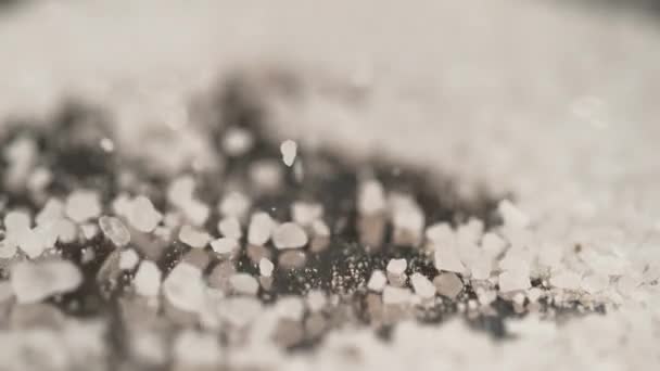 MACRO, DOF: Witte suiker wordt over het granieten aanrecht gestrooid. — Stockvideo