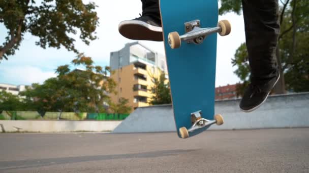 CLOSE UP: Невпізнаваний чоловік стрибає зі скейтбордом і приземляється 360 фліп . — стокове відео