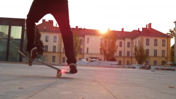 CLOSE UP: Man does a fakie kickflip while skateboarding around the square. — Stock Video