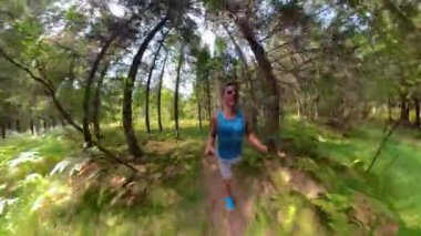 Formda bir adam mükemmel bir yaz gününde manzaralı ormanda koşuyor..