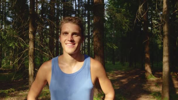 PORTRAIT: Glad manlig joggare ler efter att ha avslutat en rolig ridtur i skogen — Stockvideo