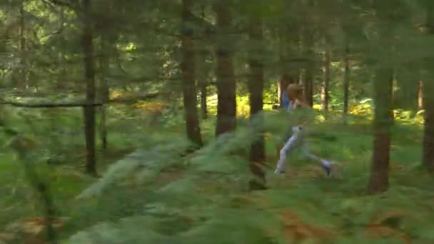 Lassú MOTION: Fit fiatal pár sportruházat fuss le egy keskeny erdei ösvényen. — Stock videók