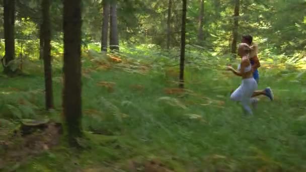 SLOW MOTION: Training partners lopen samen door de schilderachtige groene bossen. — Stockvideo