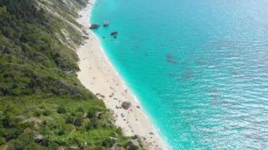 Uzak beyaz bir kumsal ve turkuaz bir denizin üzerinden göz kamaştırıcı bir manzara..