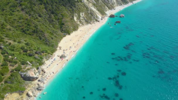 DRONE: Pocos turistas disfrutan de sus vacaciones en una playa escondida en Lefkada . — Vídeo de stock