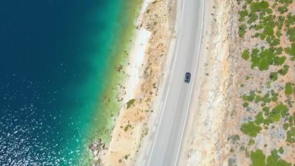DRONE: Turista autó vezet végig a csillogó óceán egy tökéletes nyári napon. — Stock videók