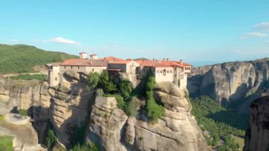 Taş bir oluşumun üzerine inşa edilmiş eski Yunan manastırının etrafında uçmak