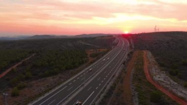 Renkli günbatımı sakin kırsal kesimde koşarak otoyolu aydınlatıyor..
