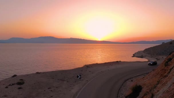 DRONE: Auto rijdt langs de asfaltweg langs de prachtige kustlijn. — Stockvideo