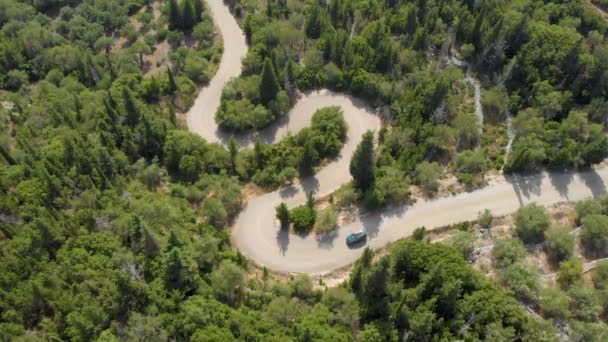 TOP DOWN: Flying above the blue SUV navigating the hairpin turns in Lefkada. — Stock Video