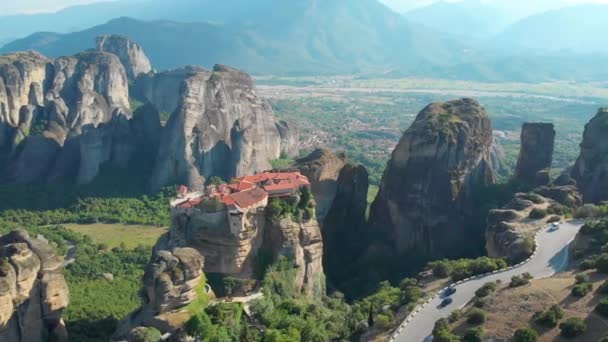 AERIAL: Voando acima de uma estrada cênica do asfalto que conduz após um monastery grego velho. — Vídeo de Stock