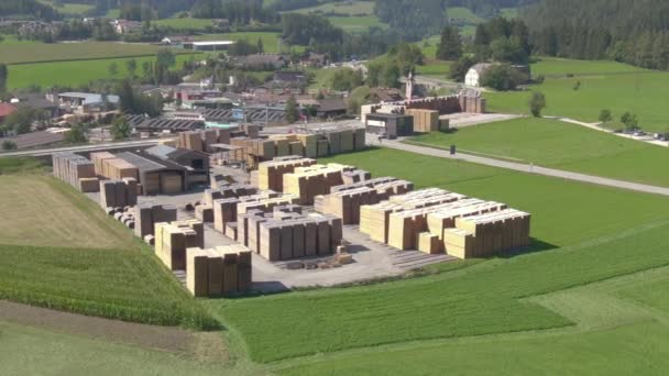 АЭРИАЛ: Мбаппе едет в сторону деревни и мимо большой пивоварни в солнечной Австрии — стоковое видео