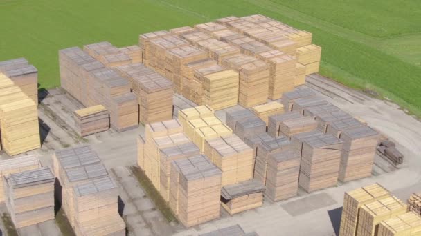 DRONE: Vista aérea de pilhas ordenadamente organizadas de madeira de pinho que jazem em uma madeira serrada — Vídeo de Stock