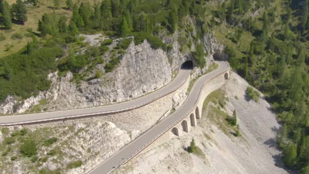 DRONE: Überflug eines Viadukts und eines Bergstraßentunnels in den Dolomiten, Italien. — Stockvideo