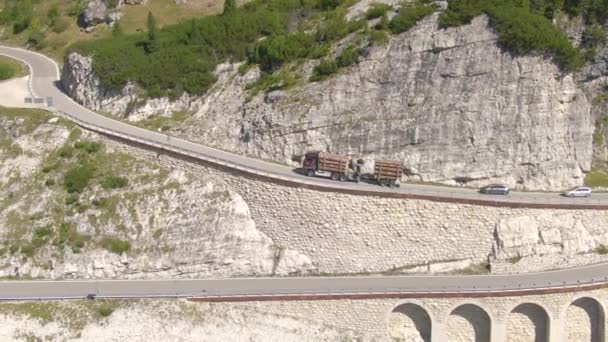 DRONE: Camión que transporta carga pesada de madera conduciendo en un paso de montaña en Italia . — Vídeo de stock