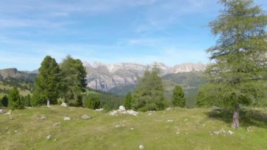 Güneşli bir bahar gününde büyük bir otlağın üzerinden Dolomitlere doğru uçmak.