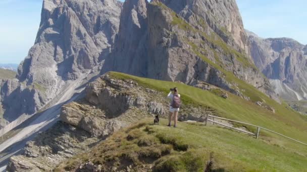 DRONE: Женщина-туристка останавливается на вершине горы, чтобы сфотографировать пейзаж — стоковое видео