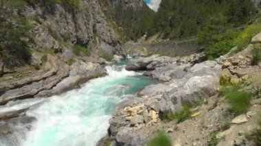 Zümrüt nehrin üzerinde uçarken turist arabaları akıntılar boyunca yol alır.