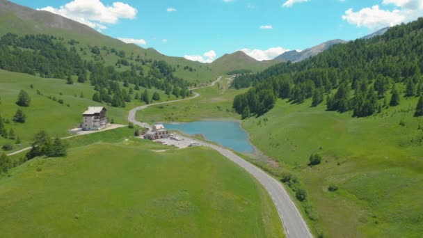 DRONE: Fliegen auf einer leeren Straße, die durch das Tal und an einem See vorbei führt. — Stockvideo