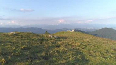 DRONE: Uçuk dağ bisikletçileri dik otlak bir tepede bisikletlerini pedal çeviriyorlar.
