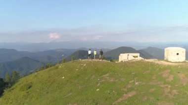 Dağ bisikleti sürerken doğayı gözlemleyen üç turistin üzerinden uçmak.