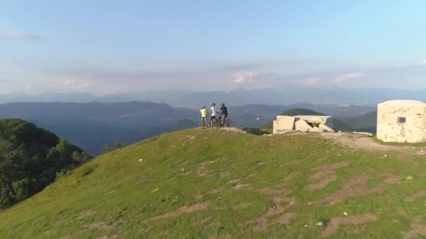 DRONE: Grupo de amigos high fives após passeio de bicicleta bem sucedido em montanhas verdes — Vídeo de Stock