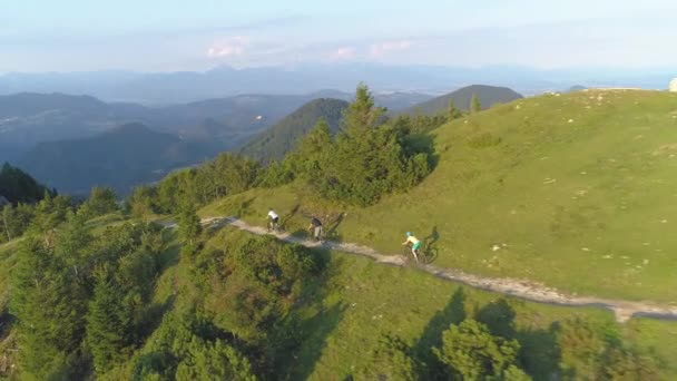 AERIAL: Um grupo de ciclistas de downhill extremos aceleram por um caminho panorâmico de cascalho. — Vídeo de Stock