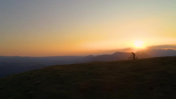 SILHOUETTE Volando a lo largo de ciclismo de descenso turístico extremo en la pintoresca mañana de verano — Vídeos de Stock