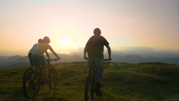 AEREO: Tre ciclisti di fondo che salgono ai margini di una collina e danno il cinque — Video Stock