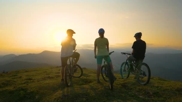 SUN FLARE: Trzech przyjaciół obserwować wieczorną przyrodę po podróży rowerem górskim. — Wideo stockowe