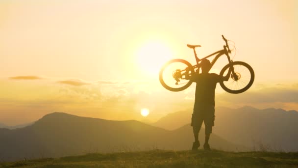 ESPACIO DE LA COPIA: El hombre excitado levanta su bicicleta por encima después de un viaje exitoso . — Vídeos de Stock