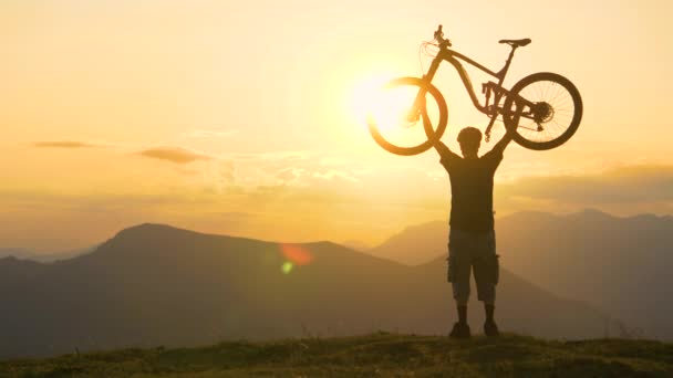 COPY SPACE: El ciclista celebra el final de un largo viaje a campo traviesa al atardecer — Vídeos de Stock